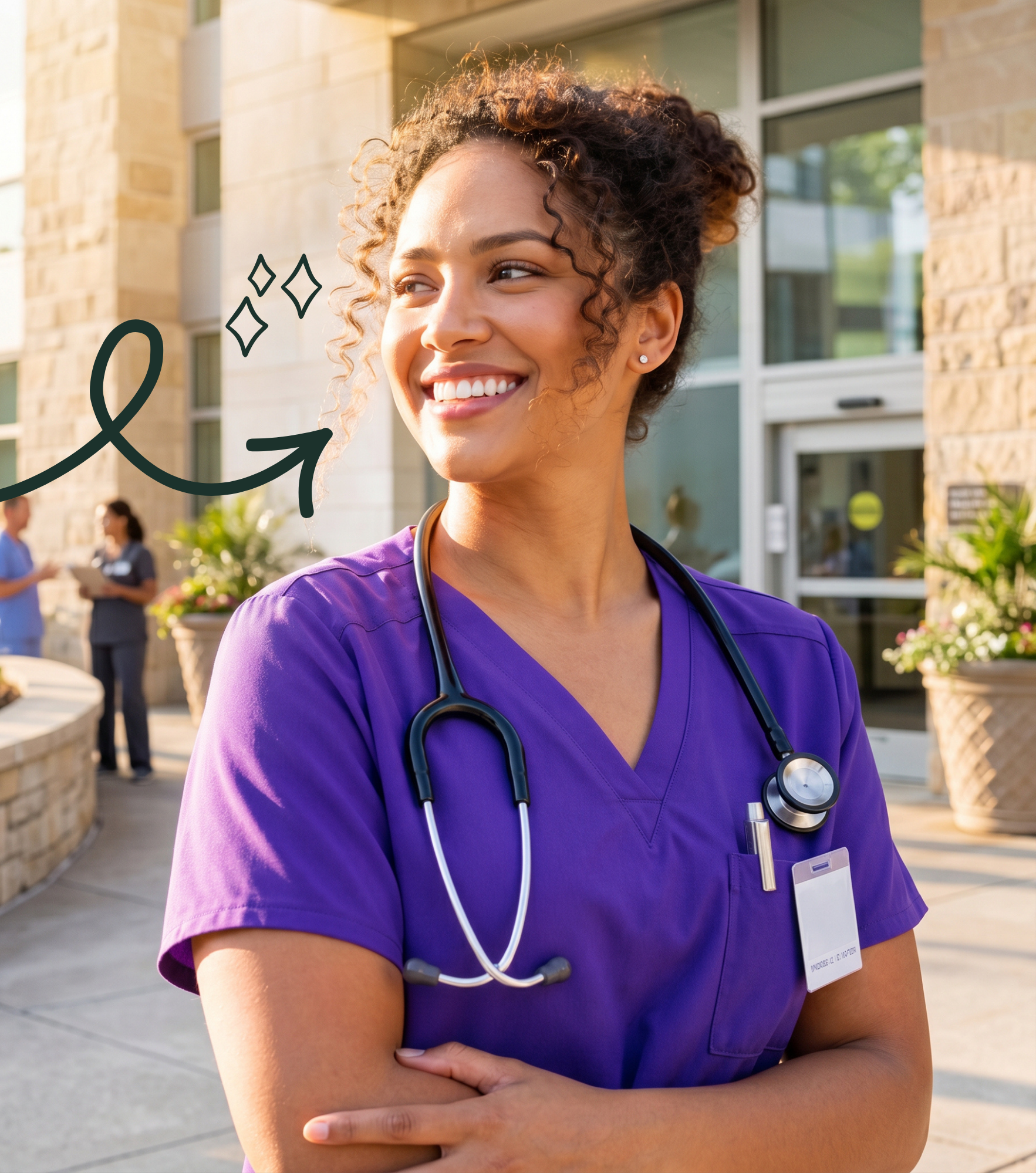 Smiling nurse in purple scrubs outside a hospital